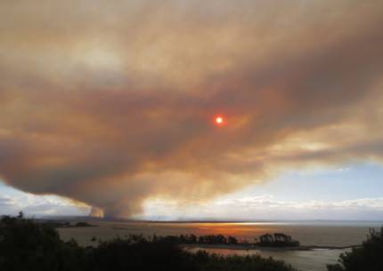 Column of smoke billows across the sky obscuring sun in Tasman Bay, Nelson.