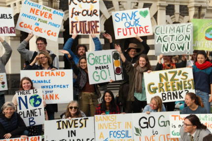 350 Dunedin hold signs that read 'Green means Go', 'Ensure your bank never invest your money in coal, oil, and gas', 'NZ's Greenest Bank?', 'Banks invest in a fossil free future'. 'demand a sustainable investment from your bank'