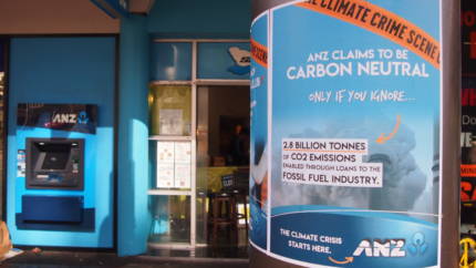 Poster reads "ANZ claims to be carbon only if you ignore the 2.8 billion tonnes of carbon enabled through loans to the fossil fuel industry. The climate crisis starts here -ANZ" ANZ atm in background