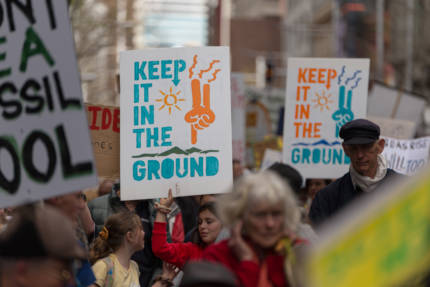 Keep it in the ground poster being held up in a crowd.