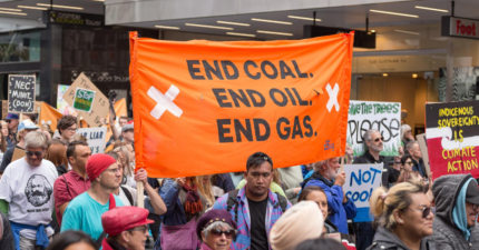 Image from Aotearoa climate strike. A group of people are holding a large banner reading 'end coal, end oil, end gas'