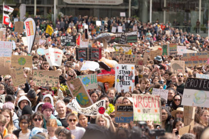 Hundreds of people holding signs at Auckland Climate Strike 2019