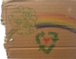 A piece of card with a green tree, a rainbow and a green recycling sign with a heart in the middle