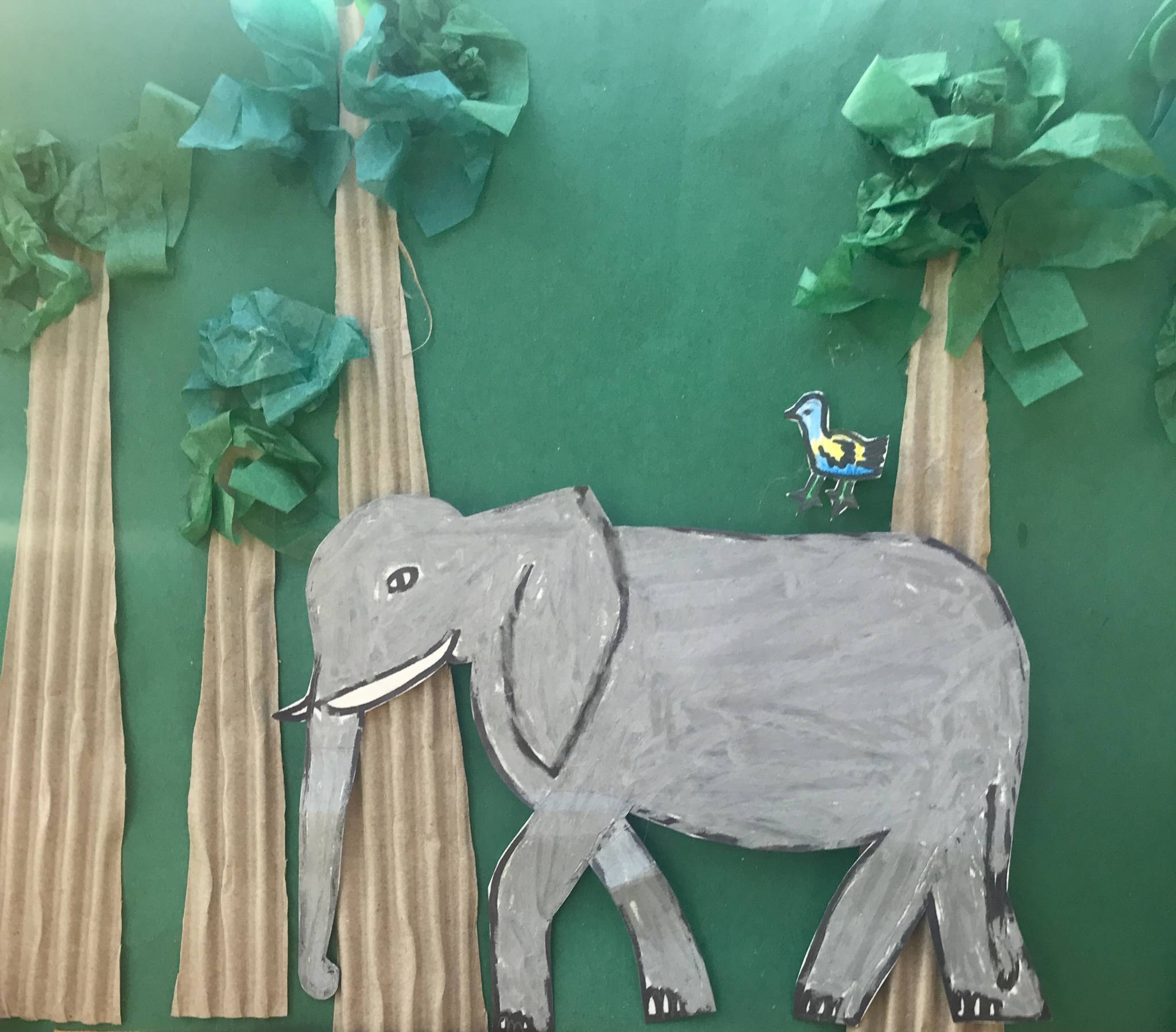 Cardboard artwork of an elephant walking through the forest