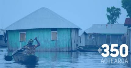 Image of flooded village in the pacific, lady on a boat