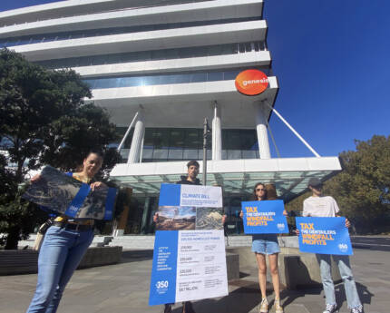 Volunteers of 350 Auckland protesting outside the Genesis office. It is a bright sunny day and they are holding a "climate bill" signs that read "Tax the gentailers windfall profits", and photos of the aftermath of Cyclone Gabrielle (flooding and powerlines fallen down).