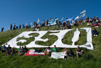 People sitting in grass with large 350 letters in the grass.