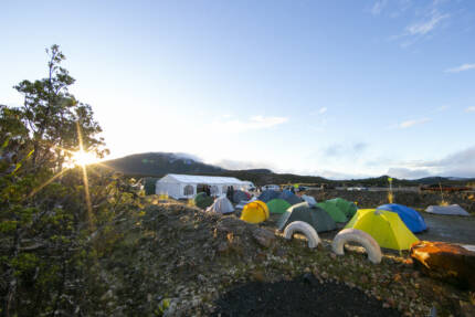 Encampment in morning light. You can see tents and a big marquee, behind it are the hills