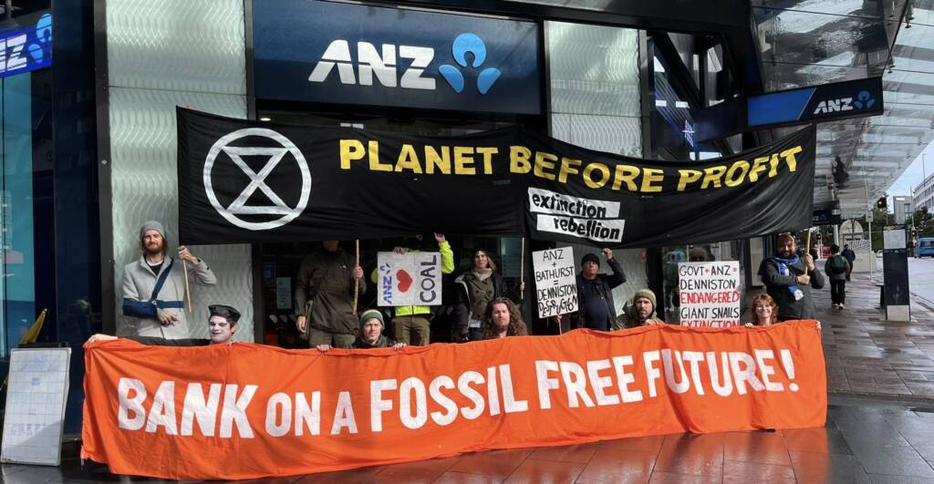 Auckland protest with people outside branch. Banners read "Planet before profit and "Bank on a fossil free future"